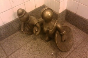 Little bronze people in the subway. 8th Ave.